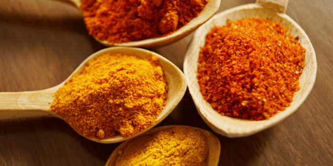Assuaged-Powdered-Turmeric-In-Wooden-Spoons-Image (899 x 450 px)
