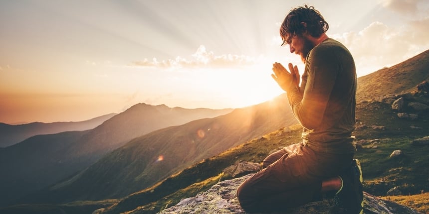 Prayer on mountain at sunrise