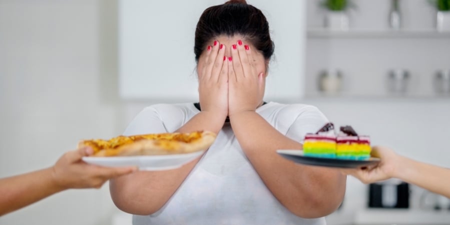 woman-covering-her-face-with-hands-while-she-is-offered-cake-and-pie