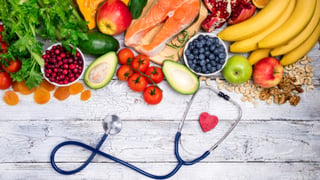 healthy foods on a table and a heart stethoscope