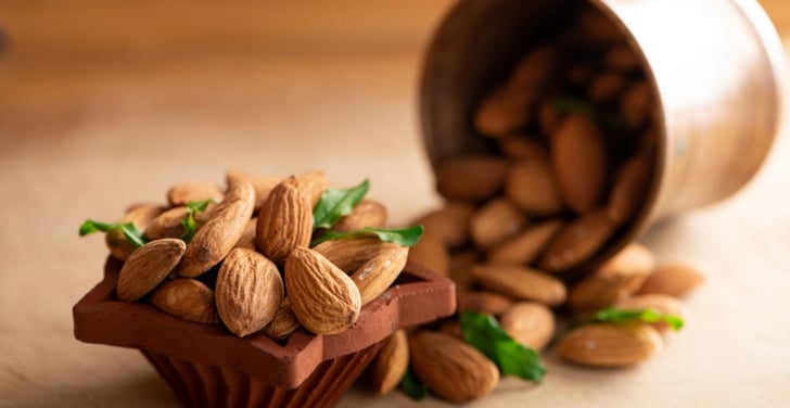 Assuaged-Blog-Almonds-in-Cup-Green-Leaves-Image