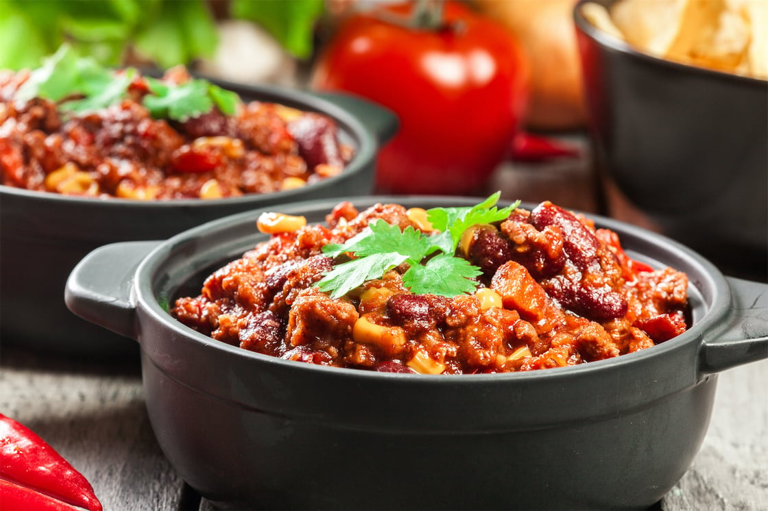Bowls of hot vegan chili with beans, tomatoes and corn