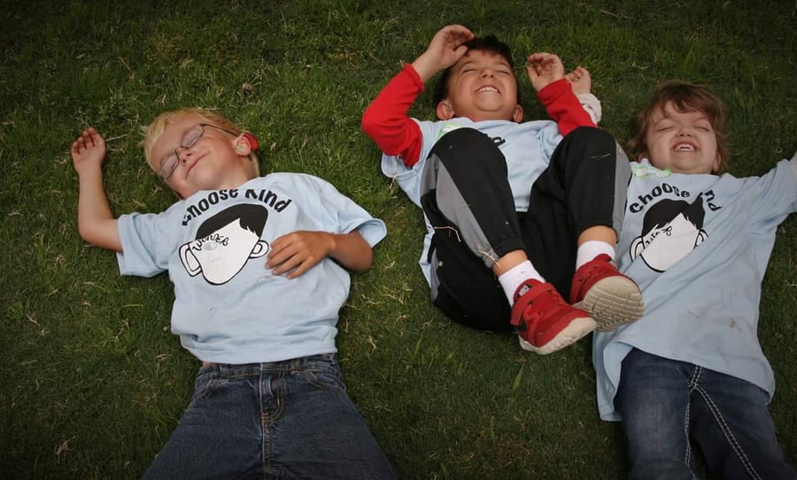 children playing wearing tshirts surrounding the film wonder choose kind