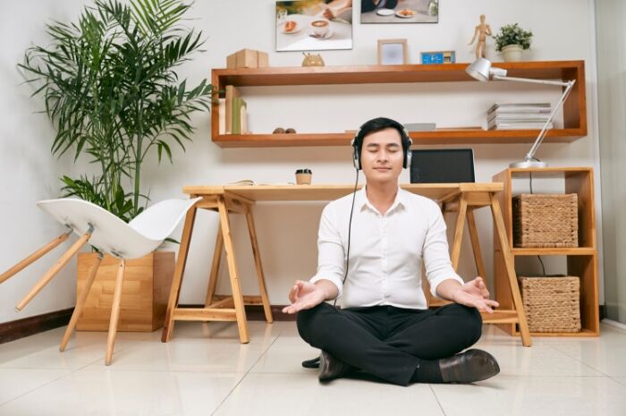 Man-Meditating-in-office-with-headphones-recharging
