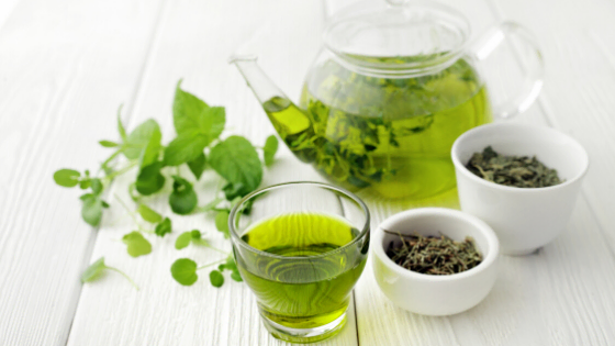 fresh green tea with teapot and leaves 