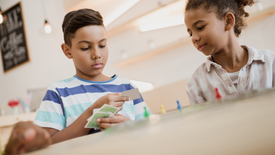 little boy and girl children playing cards and board games