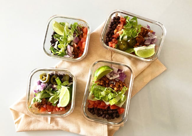 Meal Prep Tempeh Taco Bowls with Non-Dairy Sour Cream in containers