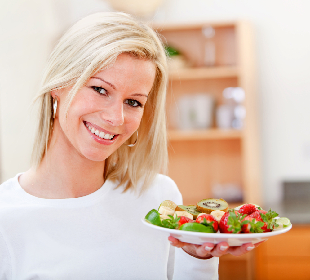 Healthy eating woman with fruits and smiling