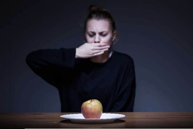 Woman with anorexia refusing to eat an apple