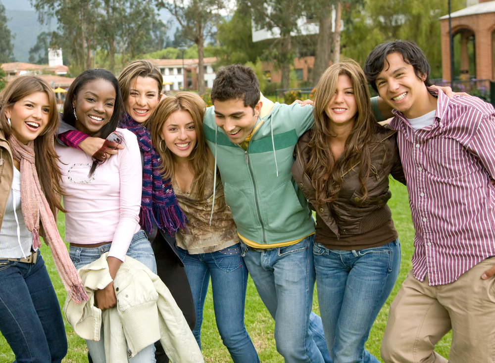 happy group of friends smiling outdoors in a park