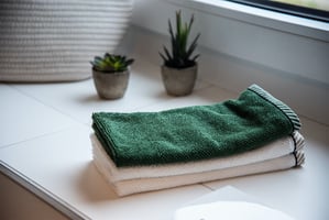 clean towels folded on a clean counter with plants in background