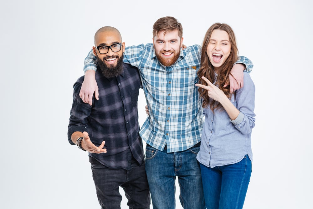 Group of happy three friends in casual wear standing and laughing